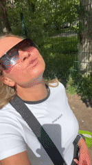 Woman in sunglasses walks Perm streets during sunny morning