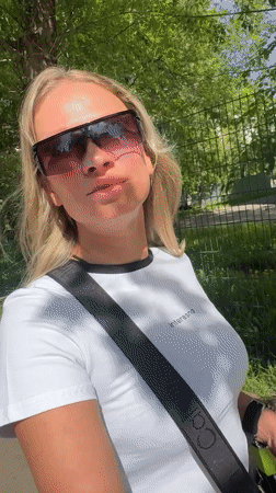 Woman in sunglasses walks Perm streets during sunny morning