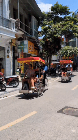 Hanoi streets buzzing with flags, cyclos, and daily routines
