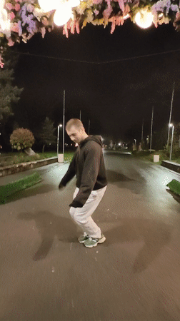 Man performs acrobatic dance under illuminated butterfly archway in Bulgaria