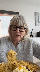 Woman prepares lunch with curious cat in French kitchen