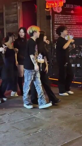 Young people walk city streets at night in Chongqing