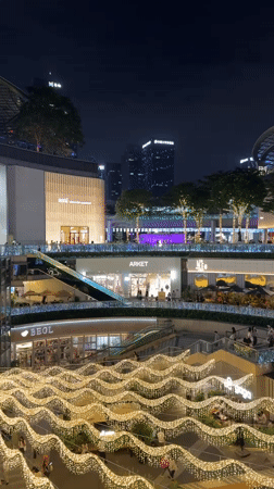 Evening crowds gather at illuminated Tianhe District shopping center