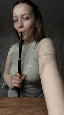 Woman smokes hookah indoors in Reshetnikovo, Russia