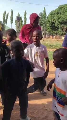 Children celebrate with decorated cake, dancing in Akwanga, Nigeria