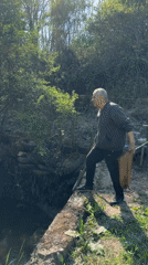 Couple fishing with net at woodland stream in Bulgaria