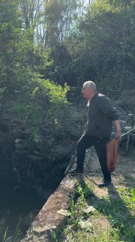 Couple fishing with net at woodland stream in Bulgaria