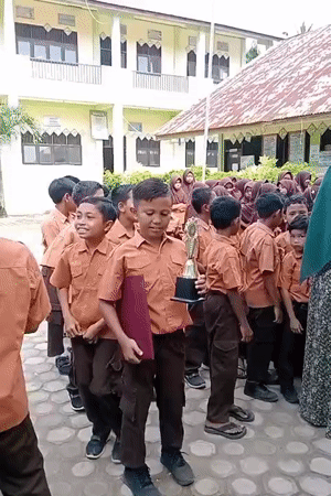 Students celebrate with a trophy at a Keudekrueng school