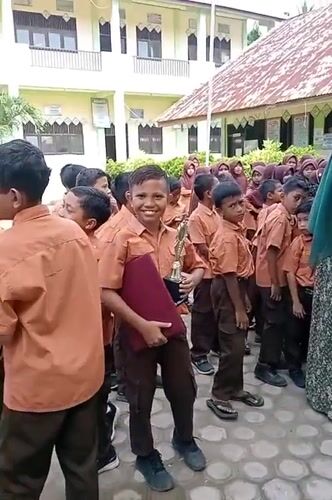 Students celebrate with a trophy at a Keudekrueng school