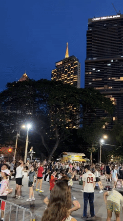 Diverse crowd gathers at Bangkok park during evening hours