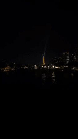 Eiffel Tower glowing at night, Seine in the foreground
