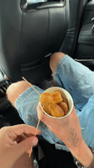 Passenger enjoys skewered snacks in car in Zhangjiajie