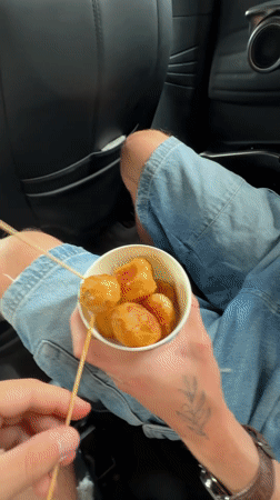 Passenger enjoys skewered snacks in car in Zhangjiajie