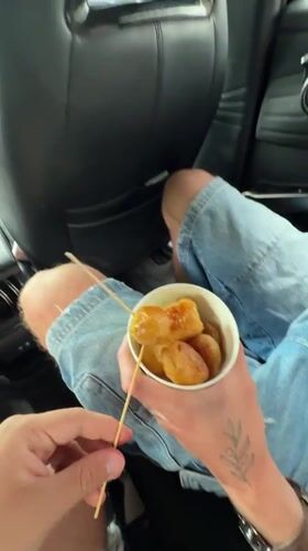 Passenger enjoys skewered snacks in car in Zhangjiajie