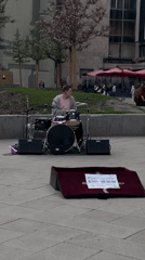 Street drummer performs in public square with full kit