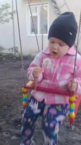 Toddler enjoys swing time in Volochysk backyard