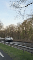 Barge travels canal in Erp amid spring foliage