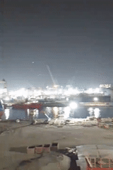 Bojonegara shipyard at night, cranes and hulls under bright lights