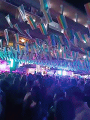 Nighttime crowd gathers under rainbow flags in Playa Del Inglés