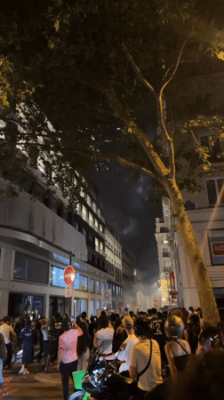 Large crowd gathers on Paris street amid smoke