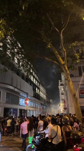 Large crowd gathers on Paris street amid smoke