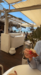 Woman dines at beachside restaurant in Herzliya