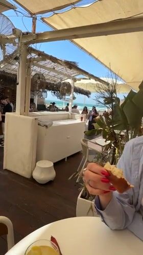 Woman dines at beachside restaurant in Herzliya