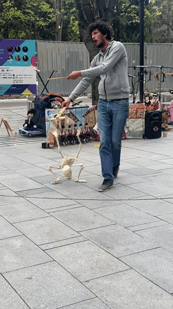 Street performer operates skeleton puppet in Stara Zagora park
