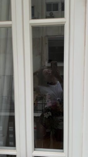 Woman takes flower bouquet selfie in Amman window reflection