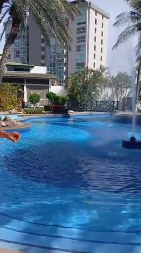 Pool scene with woman stretching, father present in Porlamar
