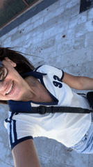 Woman films sunny walk near letter sculpture in Tivat