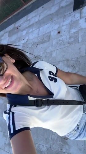 Woman films sunny walk near letter sculpture in Tivat