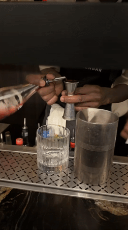 Bartender crafts cocktails during evening service at Cape Town ramen bar