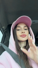 Woman in pink makes playful gestures during car ride