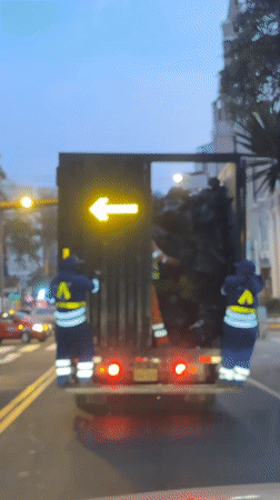 Garbage collectors work evening shift on Miraflores street
