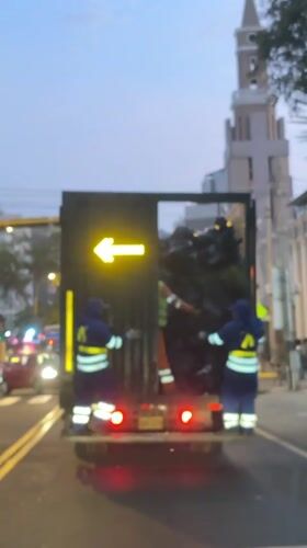 Garbage collectors work evening shift on Miraflores street