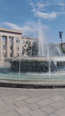 Morning scenes captured around public plaza fountain and building