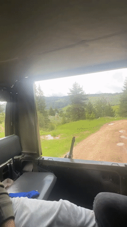 Military vehicle travels rural dirt road near Iagodina, Bulgaria