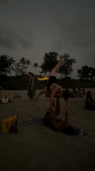 Beachgoers practice acroyoga and juggling at Arambol Beach dusk