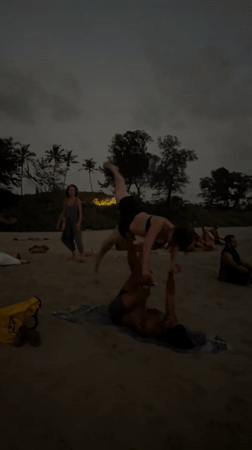 Beachgoers practice acroyoga and juggling at Arambol Beach dusk