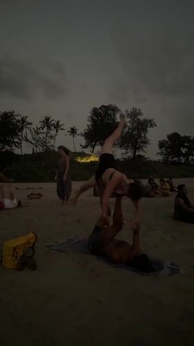 Beachgoers practice acroyoga and juggling at Arambol Beach dusk