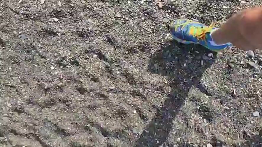 Person takes sunny beach walk in Chabkwara, Abkhazia