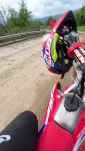 Red dirt bike with helmets spotted on rural road