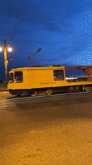 Evening scenes in Saint Petersburg: maintenance tram, couple crossing street