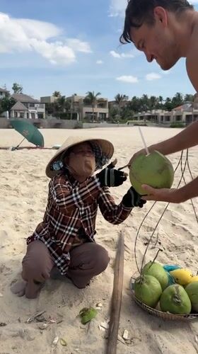 Coconut vendors serve tourists on Vietnamese beach in Phu Thuy Ward