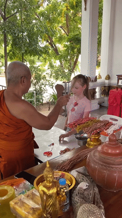 Buddhist monk conducts blessing ceremonies for visitors in Thailand