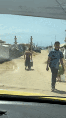 Gaza residents documented carrying supplies amid widespread urban destruction