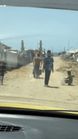 Gaza residents documented carrying supplies amid widespread urban destruction