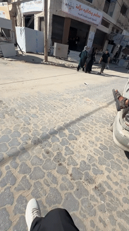 Young men gather on Gaza streets amid damaged buildings
