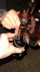 Two people toast with Zbiteń bottles outdoors after dark